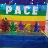 ... come quello che ha realizzato riempiendo le statuine di glitter e brillantini colorati sullo sfondo di una bandiera della pace